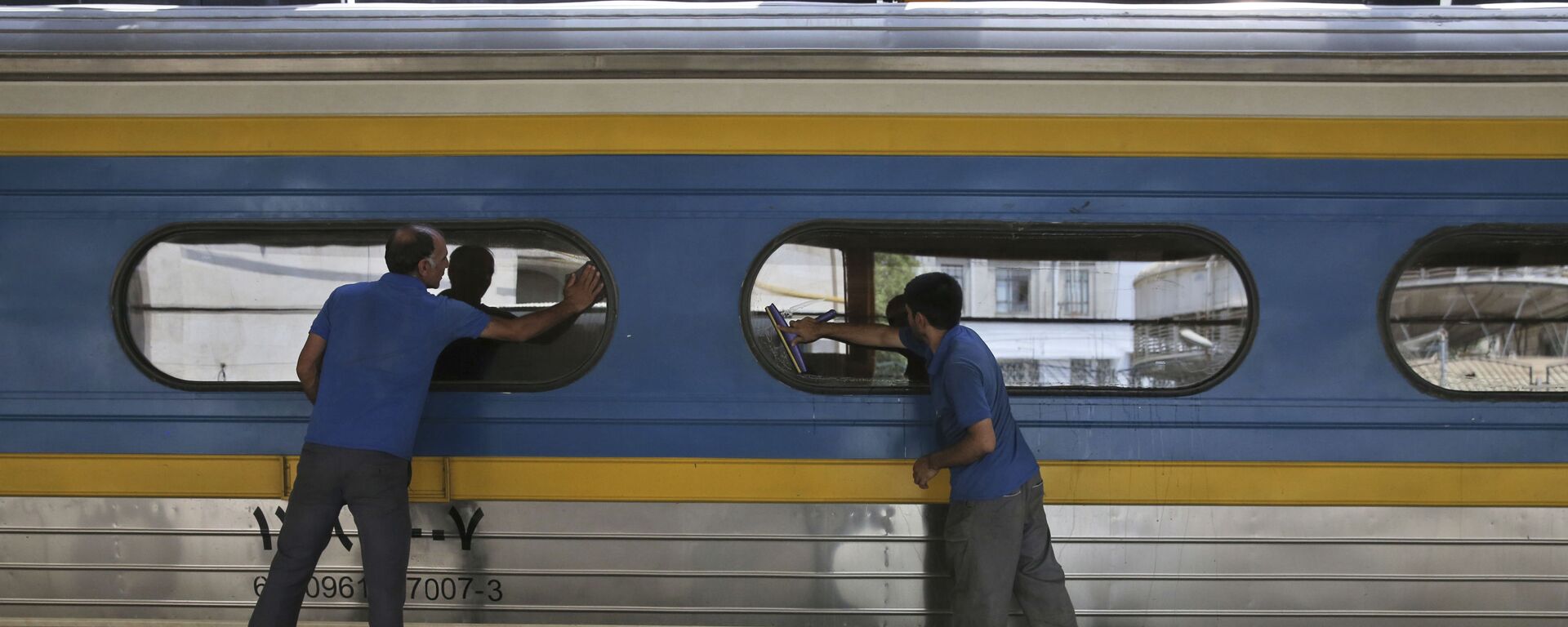 Двое рабочих моют окна у вагоне поезда на центральном вокзале Тегерана - Sputnik Тоҷикистон, 1920, 10.12.2020