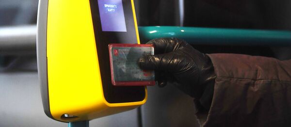 Пассажир прикладывает билет к валидатору в автобусе, архивное фото - Sputnik Тоҷикистон