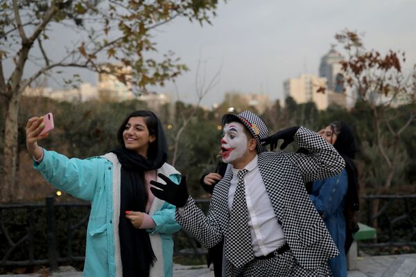 Мохаммад, иранский уличный артист в костюме Джокера фотографируется с девушкой - Sputnik Таджикистан