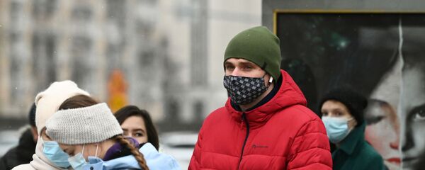 Люди в защитных масках на остановке общественного транспорта  - Sputnik Тоҷикистон