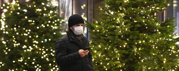 Человек идет по улице вдоль новогодних елок Человек идет по улице вдоль новогодних елок - Sputnik Тоҷикистон