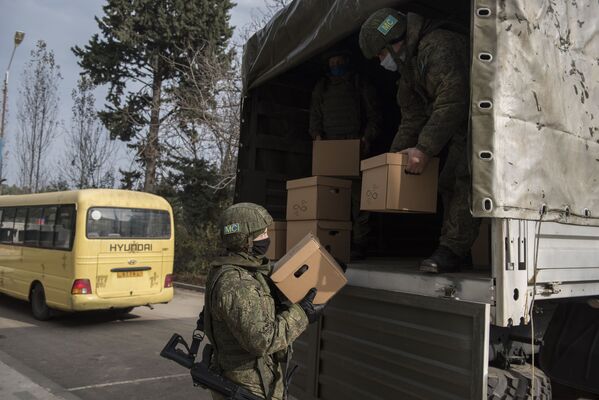 Военнослужащие российского Центра по примирению враждующих сторон выгружают коробки с гуманитарной помощью в городе Мартакерт в Нагорном Карабахе - Sputnik Таджикистан