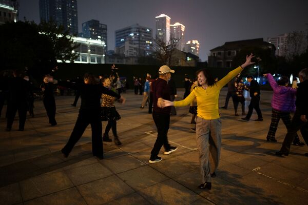 Люди танцуют ночью парке спустя год после вспышки COVID-19 в Ухане - Sputnik Таджикистан