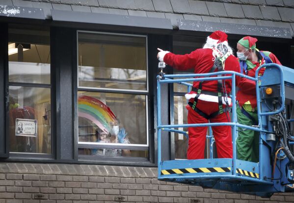 Мужчины в новогодних костюмах поддерживают пациентов детской больницы в Лидсе, Англия - Sputnik Тоҷикистон
