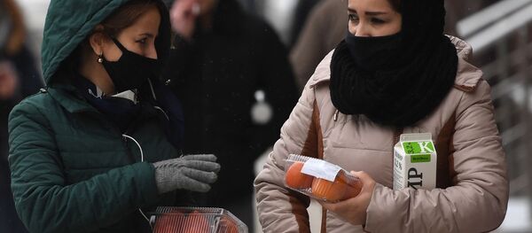 Девушки в защитных масках на одной из улиц в Москве - Sputnik Таджикистан