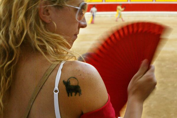 Женщина с татуировкой быка на плече во время корриды на ярмарке Сан-Фермин, Испания - Sputnik Таджикистан
