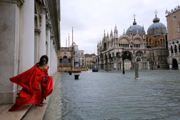 Женщина в развевающемся платье на затопленной площади Сан-Марко в Венеции, Италия - Sputnik Тоҷикистон
