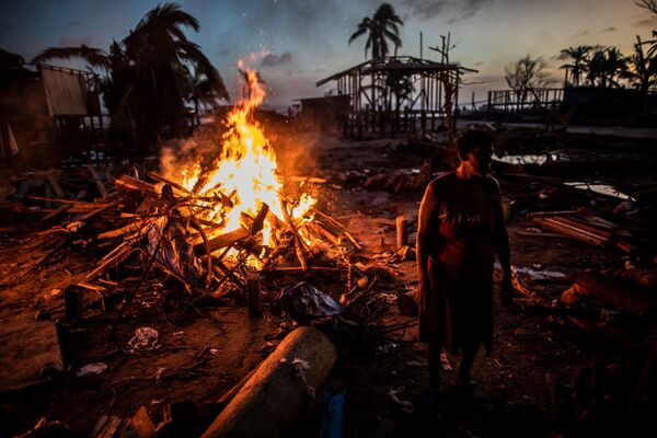 Люди сжигают мусор, оставшийся после урагана Йота в Бильви, Никарагуа - Sputnik Тоҷикистон