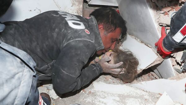 Турецкие спасатели вытаскивают ребенка из под обломков после землетрясения в Измире - Sputnik Тоҷикистон