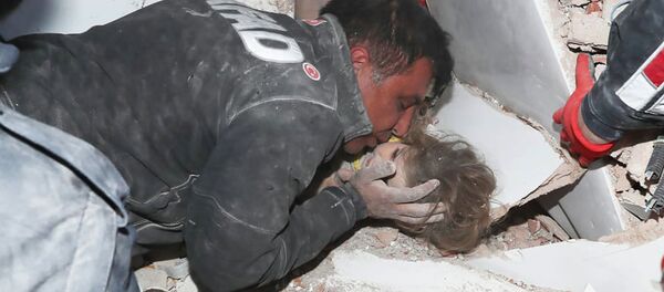 Турецкие спасатели вытаскивают ребенка из под обломков после землетрясения в Измире - Sputnik Тоҷикистон