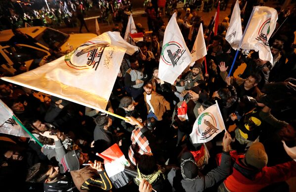 Люди с флагами во время первой годовщины со дня смерти иранского командира Касема Сулеймани и иракского командира Абу Махди аль-Мухандис в Багдаде  - Sputnik Тоҷикистон