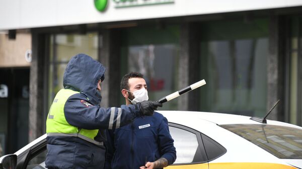 Сотрудник дорожно-патрульной службы разговаривает с таксистом на одной из улиц Москвы. - Sputnik Таджикистан