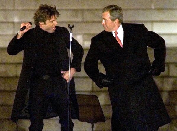 Избранный президент Джордж Буш-младший танцует с певцом Рики Мартином во время церемонии инаугурации в Вашингтоне, 2001 год  - Sputnik Таджикистан