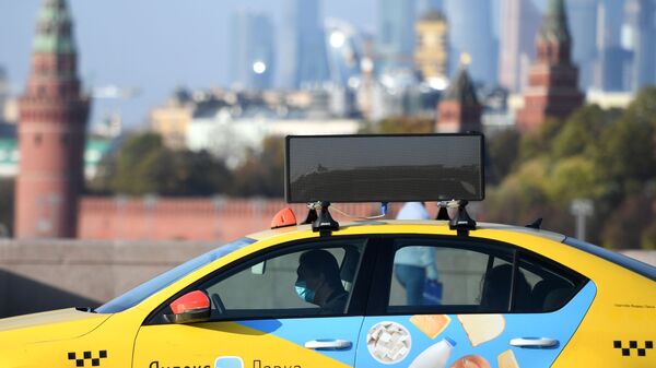 Водитель такси в защитной маске на одной из улиц Москвы. - Sputnik Таджикистан