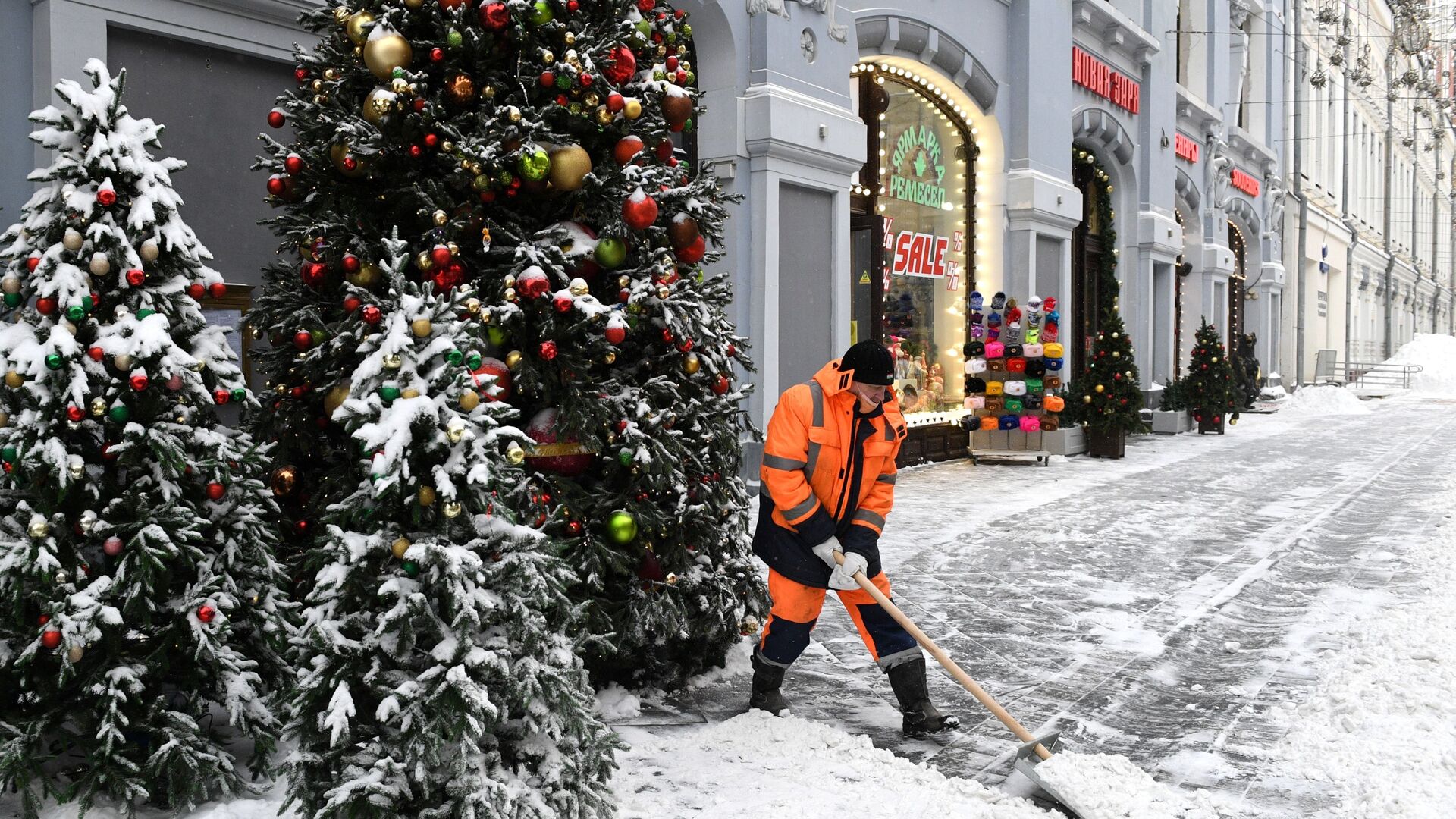 Сотрудник коммунальных услуг убирает снег на улице Москвы - Sputnik Таджикистан, 1920, 05.12.2021