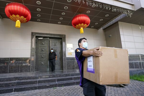 Сотрудник FedEx забирает ящик из китайского консульства в Хьюстоне - Sputnik Таджикистан