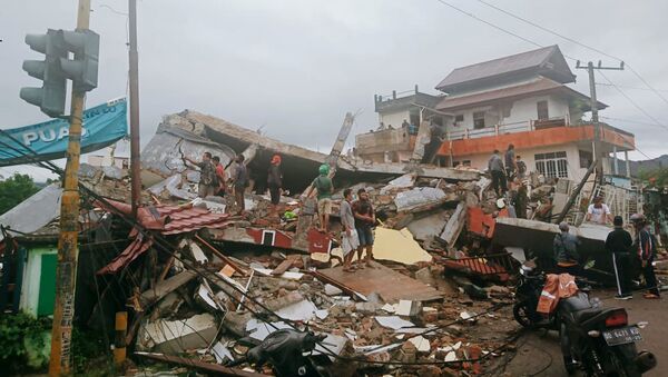 Спасатели ищут выживших после землетрясения в городе Мамаджу, Индонезия - Sputnik Таджикистан