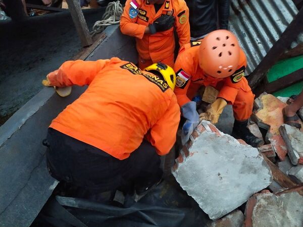 Спасатели ищут выживших среди руин здания, поврежденного в результате землетрясения в Мамуджу, Индонезия - Sputnik Таджикистан