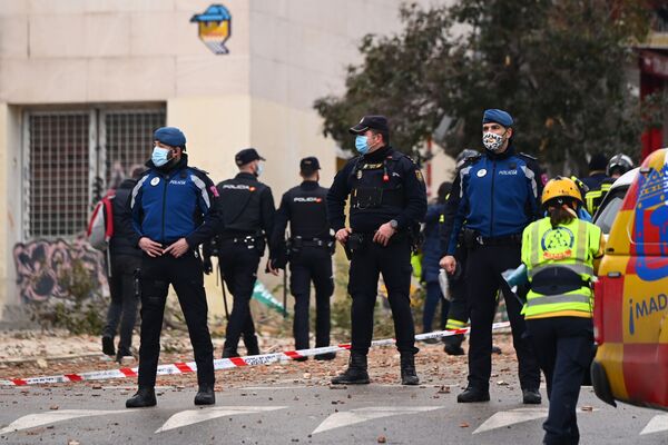 Полицейские стоят на страже возле поврежденного здания в Мадриде - Sputnik Таджикистан