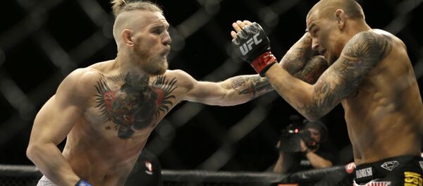 Конор Макгрегор наносит удар Дастину Порье во время боя в Лас-Вегасе - Sputnik Таджикистан