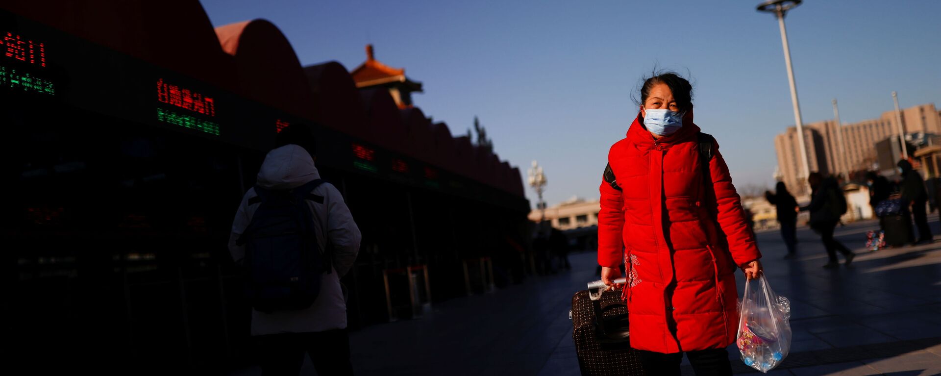 Путешественница в защтной маске у железнодорожного вокзала в Пекине, Китай - Sputnik Тоҷикистон, 1920, 27.12.2021