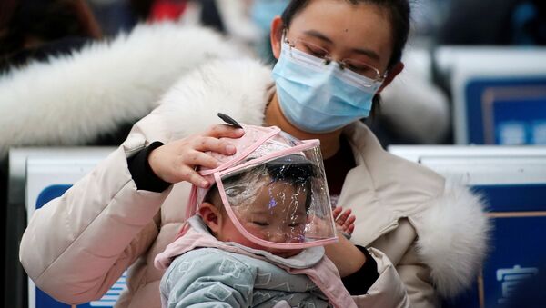 Женщина с ребенком в защитных масках на вокзале в Шанхае, Китай - Sputnik Таджикистан