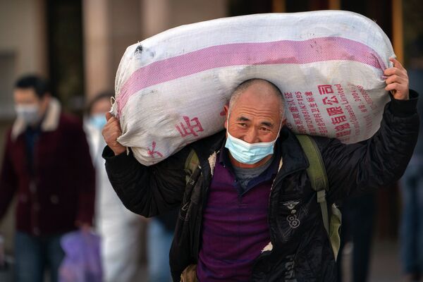 Путешественник в защитной маске с мешком на вокзале в Пекине, Китай - Sputnik Тоҷикистон