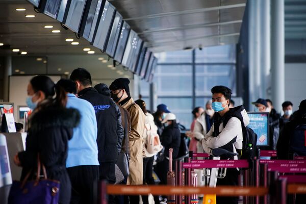 Путешественники в защитных масках в очереди в Шанхайском аэропорте, Китай - Sputnik Тоҷикистон