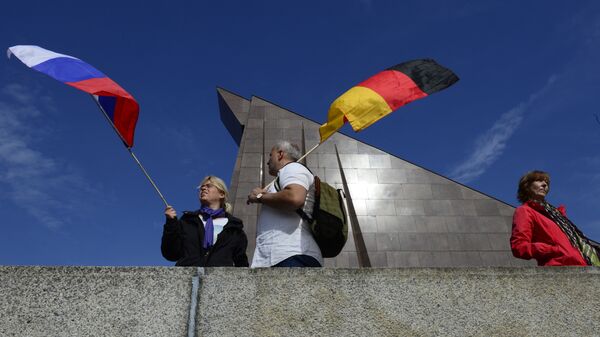 Люди держат флаги России и Германия - Sputnik Таджикистан