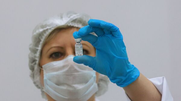 Медицинский сотрудник держит в руках ампулу с российским препаратом Спутник V - Sputnik Таджикистан