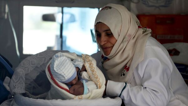 Медсестра с сиамскими близнецами в машине скорой помощи в аэропорту Саны, Йемен - Sputnik Тоҷикистон