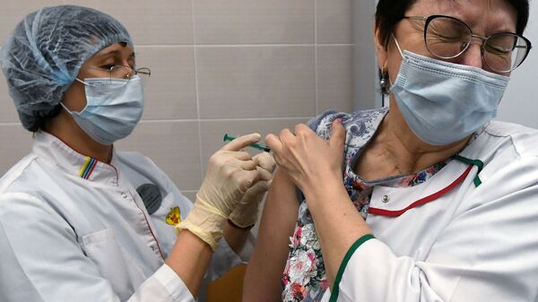 Медицинская сотрудница Сибирского федерального университета вакцинируется против COVID-19 вакциной Спутник V - Sputnik Таджикистан