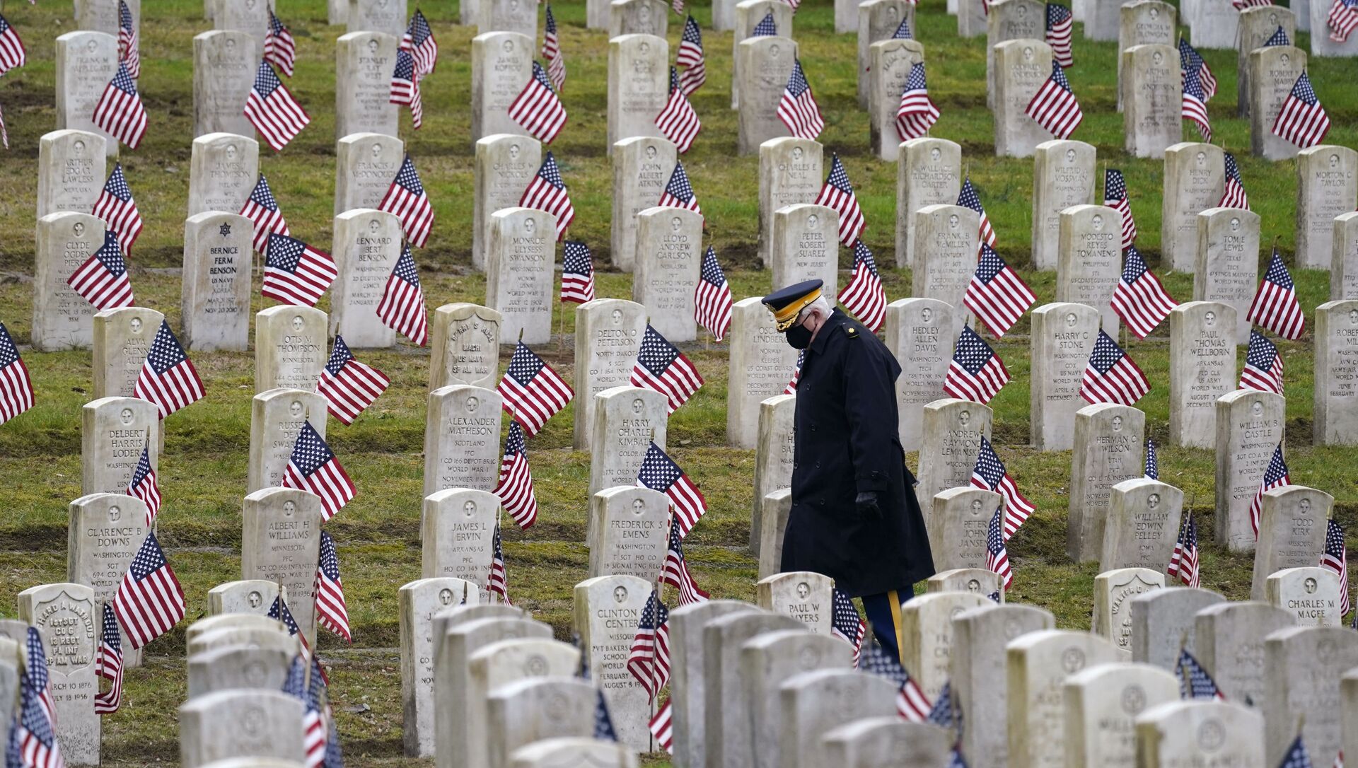 Ветеран армии США в отставке Билл МакКалли идет среди покрытых флагами могил на кладбище ветеранов, архивное фото - Sputnik Таджикистан, 1920, 11.03.2021