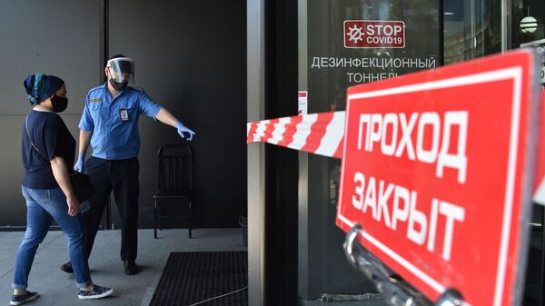 Охранник и посетитель в медицинских масках у входа в торговый центр в Бишкеке. Архивное фото - Sputnik Тоҷикистон