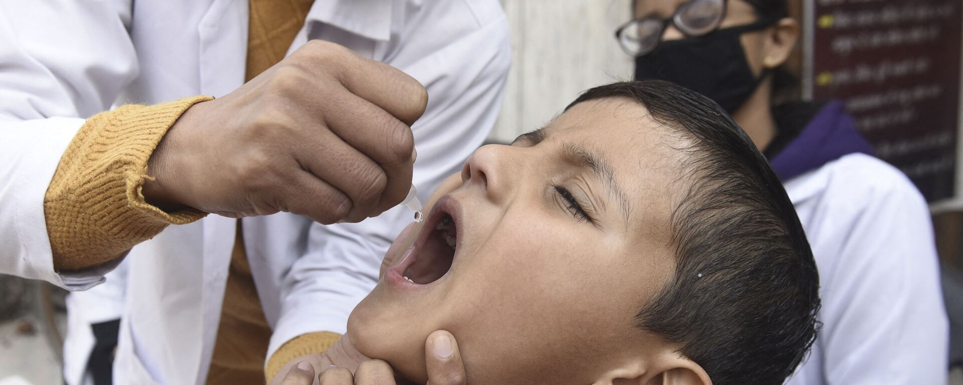 Медицинский работник вводит капли вакцины против полиомиелита ребенку - Sputnik Тоҷикистон, 1920, 24.05.2021