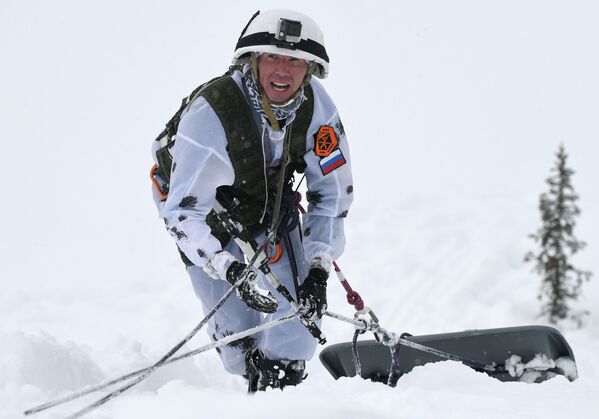 Участник конкурса во время подъема пострадавшего вверх на крутом склоне - Sputnik Таджикистан