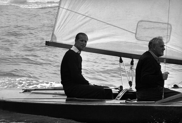 Принц Филипп во время морской прогулки со своим товарищем по парусному спорту Уффа Фокс перед стартом регаты Королевского лондонского яхт-клуба в Коусе. - Sputnik Таджикистан