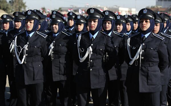 По всей строгости одеты девушки-полицейские в иракском Багдаде. Острые голубые воротнички соседствуют с традиционным восточным головным убором - хиджабом, поверх которого надета синяя фуражка с серебряным орлом  - Sputnik Таджикистан