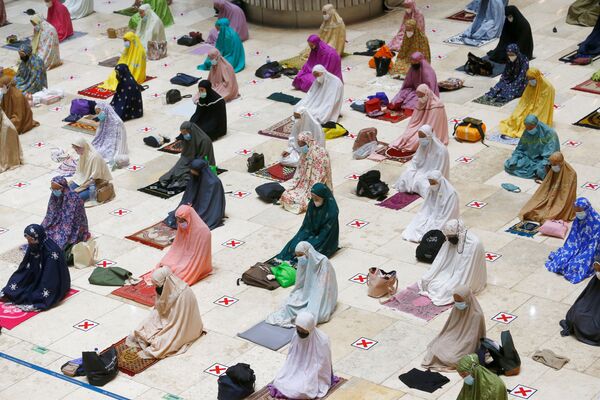 Мусульманские женщины в защитных масках молятся перед священным месяцем поста Рамадан в мечети Истикляль в Джакарте (Индонезия) - Sputnik Таджикистан