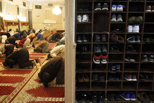 Люди разуваются перед входом в мечеть на вечернюю молитву в первый вечер священного месяца поста Рамадан в Чикагском общественном центре мусульман - Sputnik Таджикистан