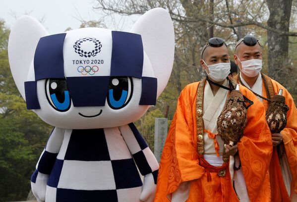 Талисман Олимпийских игр в Токио Мирайтова и буддийские монахи в защитных масках на фоне пандемии коронавируса - Sputnik Таджикистан