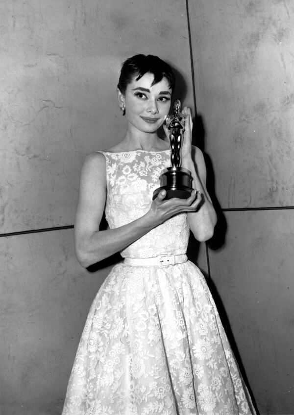 Обладательница &quot;Оскара&quot; Одри Хепберн позирует со своей статуэткой на 26-й ежегодной церемонии вручения премии &quot;Оскар&quot; в Нью-Йорке 25 марта 1954 года. Хепберн получила награду за лучшую женскую роль в фильме &quot;Римские каникулы&quot; - Sputnik Таджикистан