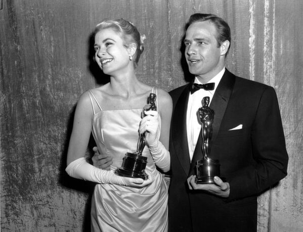 Обладатели &quot;Оскара&quot; Грейс Келли и Марлон Брандо на церемонии вручения премии Оскар в 1955 году в театре RKO Pantages в Голливуде. Келли стала лучшей актрисой года за роль в фильме &quot;Деревенская девушка&quot;. Брандо стал лучшим актером года за роль в фильме &quot;На набережной&quot; - Sputnik Таджикистан