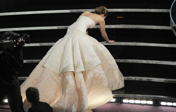 Дженнифер Лоуренс споткнулась, поднимаясь  на сцену, чтобы получить награду за лучшую женскую роль в 2013 году - Sputnik Таджикистан