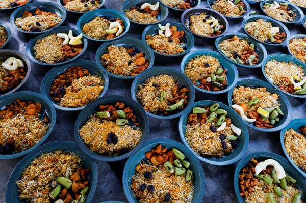 Кастрюли с вареным рисом и фруктами для раздачи людям, пострадавшим от пандемии в Пакистане - Sputnik Таджикистан