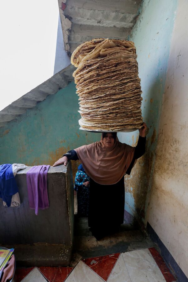 35-летняя Нур Эль-Сабах несет лепешки домой в провинции Бени-Суэйф, Египет - Sputnik Таджикистан