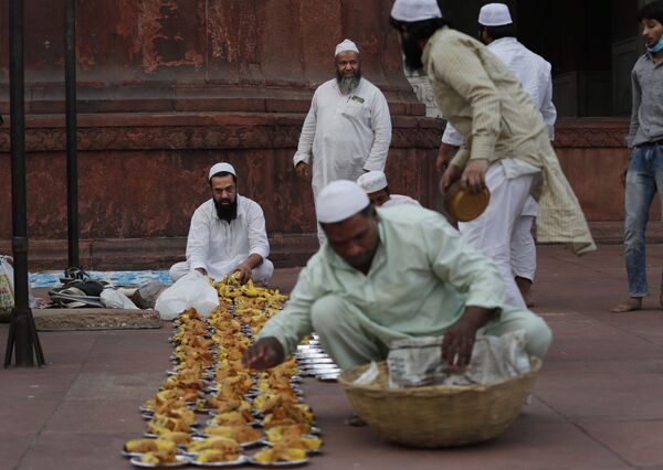 Мусульмане готовят тарелки с закусками для раздачи в первый день священного месяца Рамадан в мечети Джама в Нью-Дели, Индия - Sputnik Таджикистан