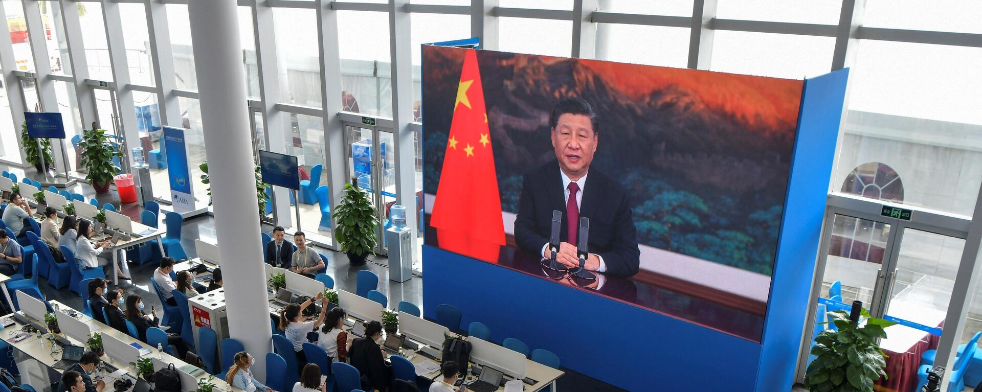 Журналисты смотрят экран, на котором президент Китая Си Цзиньпин выступает с речью на открытии Ежегодной конференции Боаоского азиатского форума (BFA) 2021 - Sputnik Таджикистан, 1920, 22.04.2021