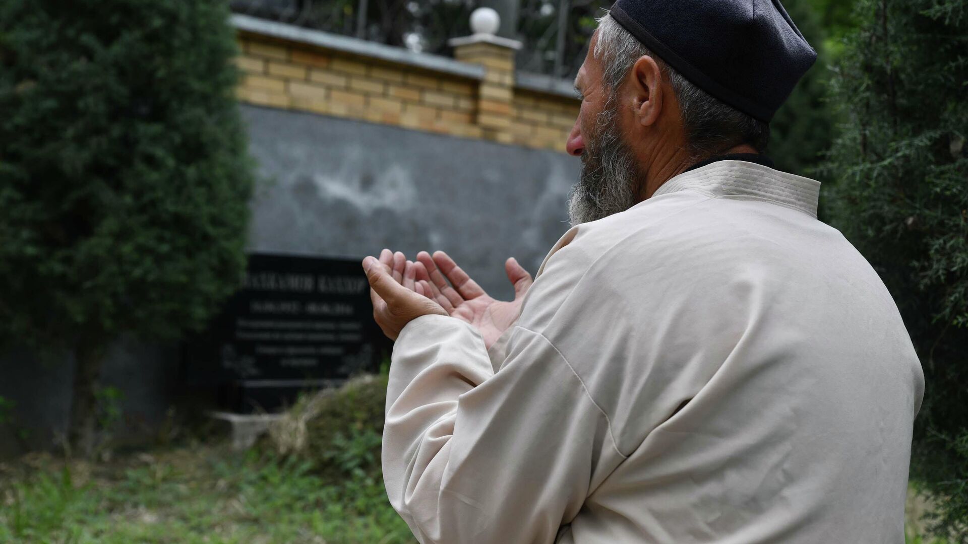 Мужчина молится на кладбище - Sputnik Таджикистан, 1920, 27.08.2022