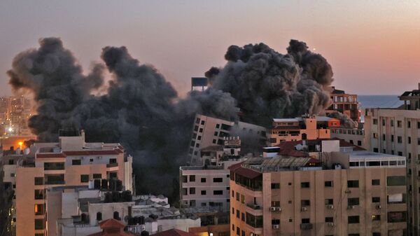 Пожарные тушат горящие многоквартирные дома после израильских авиаударов в городе Газа - Sputnik Таджикистан